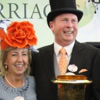 A smiling man and woman hold a trophy